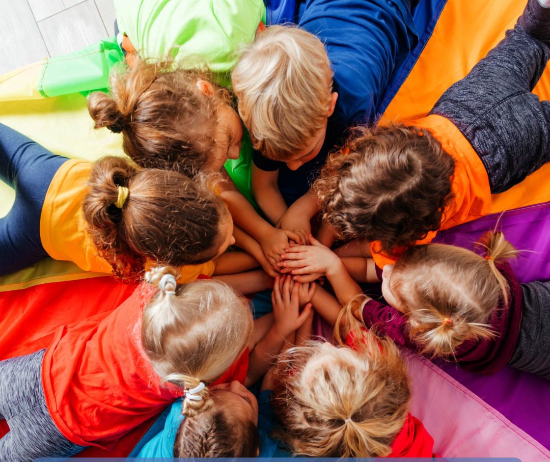 Kinder im Kreis beim Kindersport, Hände in der Mitte